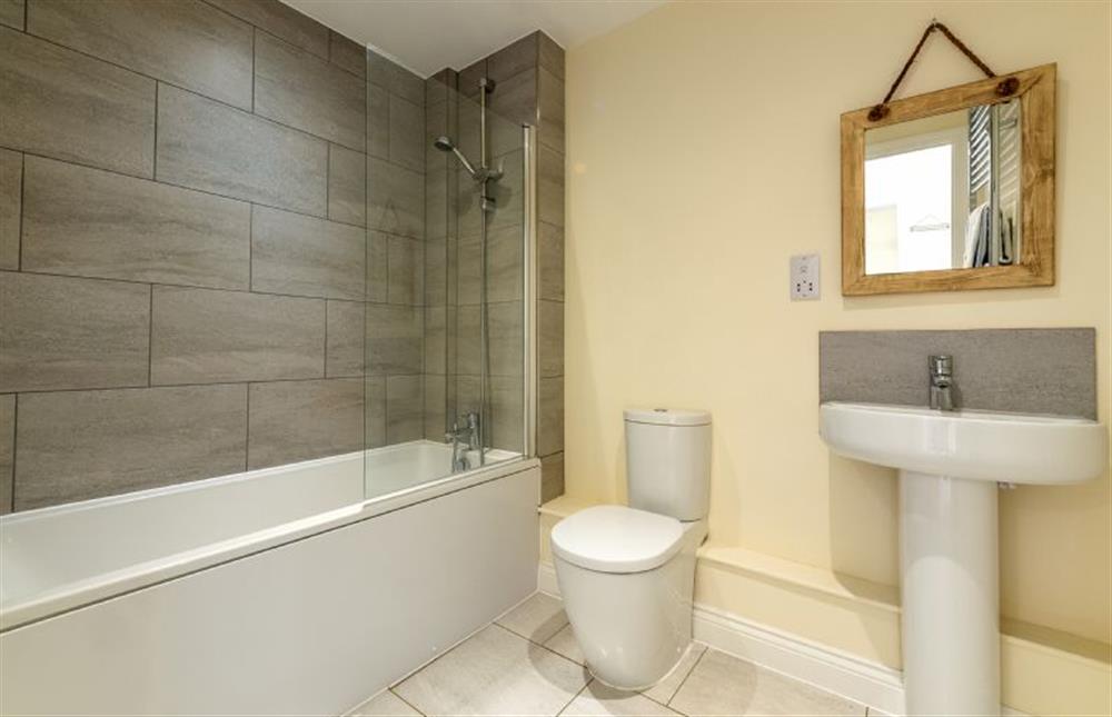 Ground floor:  Bathroom with bath with overhead shower at Seagrace, Heacham near Kings Lynn