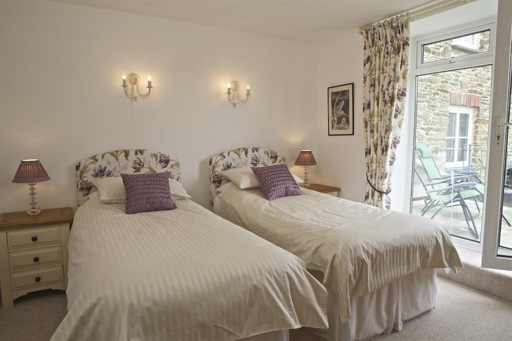 Master bedroom with two single beds (pushed together) and a door out to sun terrace with lovely views at Seagulls (Salcombe) in Fore Street, Salcombe