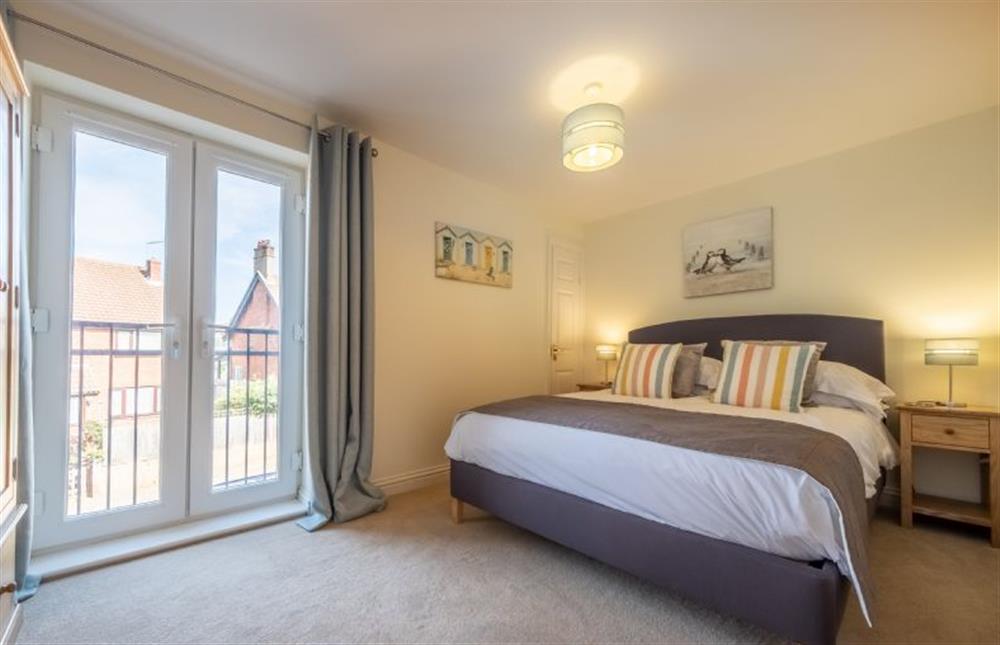 Master bedroom with king-size bed and juliette balcony at Seas the Day, Sheringham