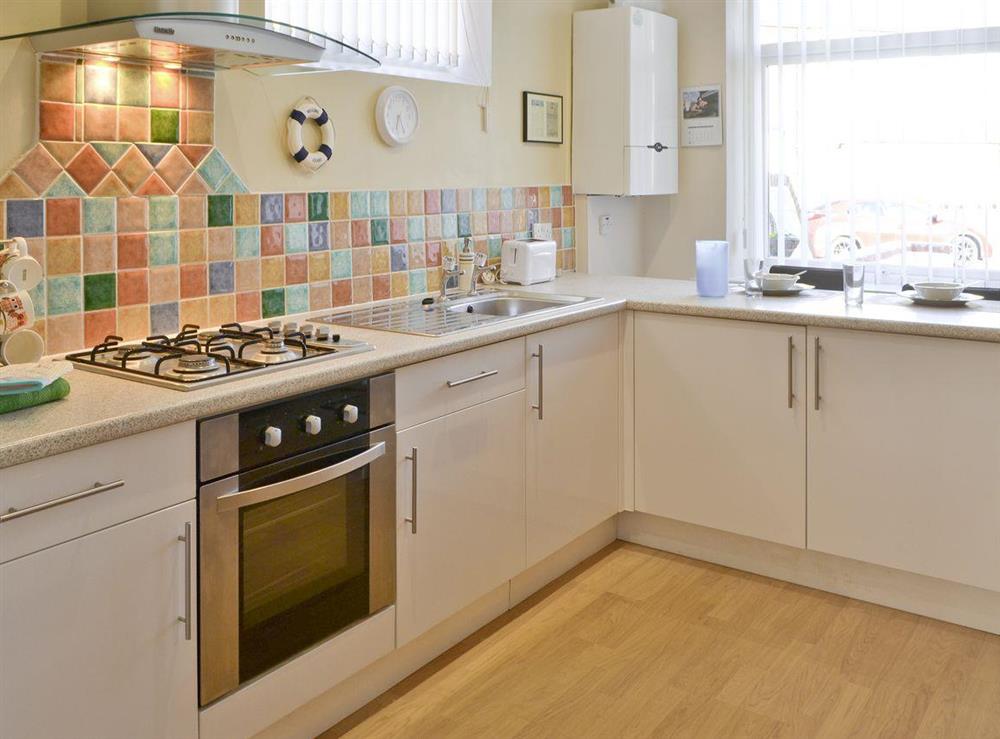 Well-equipped fitted kitchen with breakfast bar at Seashells in Newbiggin-by-the-Sea, Northumberland
