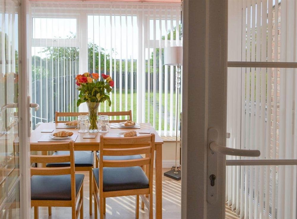 Dining area within the conservatory at Seashore Hideaway in Newbiggin-by-the-Sea, Northumberland