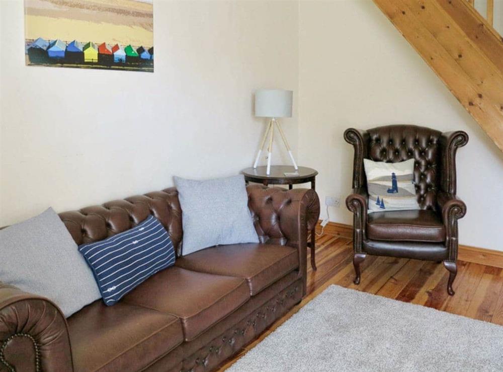 Comfy seating within living room at Jennys Cottage, 