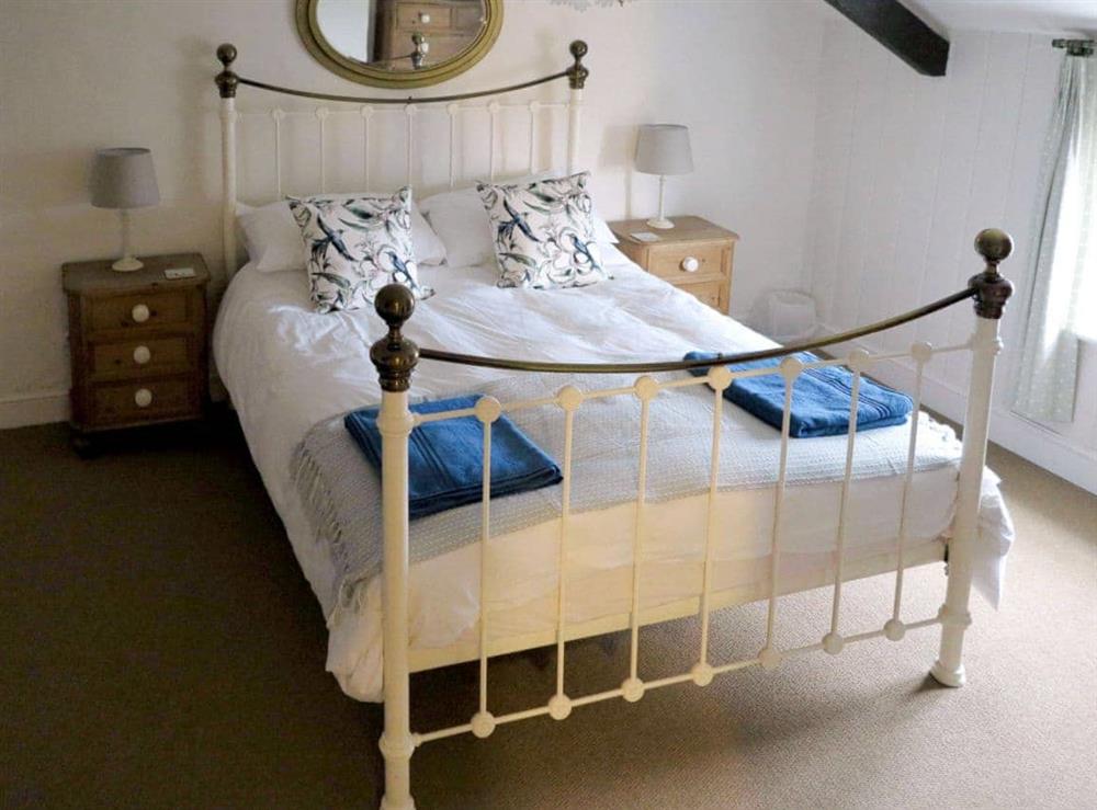 Romantic double bedroom with exposed beams at Jennys Cottage, 