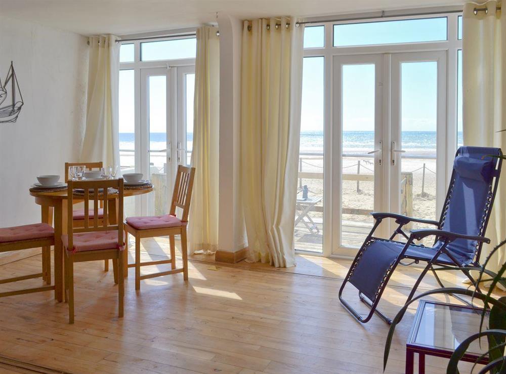 Light and airy dining area with French doors to decked seating area and beach at Seaspray in Camber Sands, Rye, East Sussex