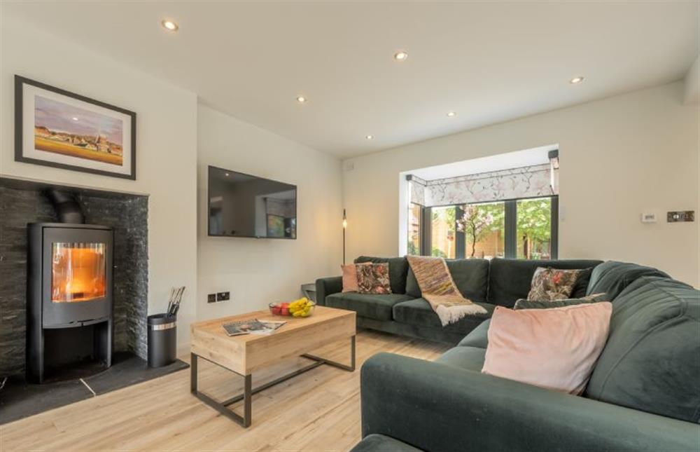 Seaspray, Norfolk: Within the open-plan living space a cosy sitting room with wood burning stove