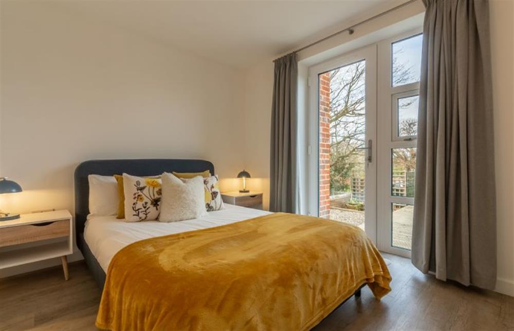 Ground floor: Bedroom two with double bed and glass door to garden at Seastiles, Salthouse near Holt