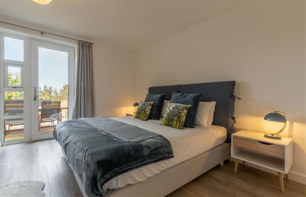 Ground floor: Master bedroom with a super-king size bed, Smart television and glass door to garden at Seastiles, Salthouse near Holt