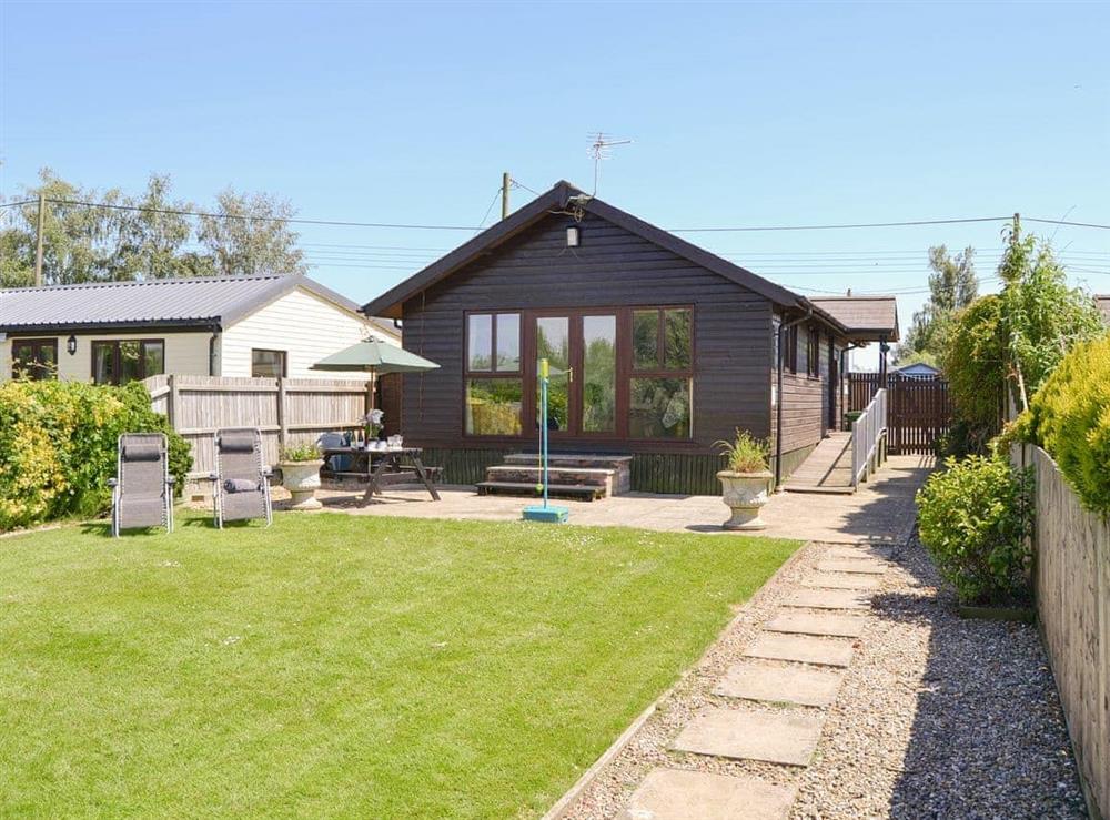 Delightful riverside holiday home with lawned garden at Serena Lodge in Brundall, Norfolk