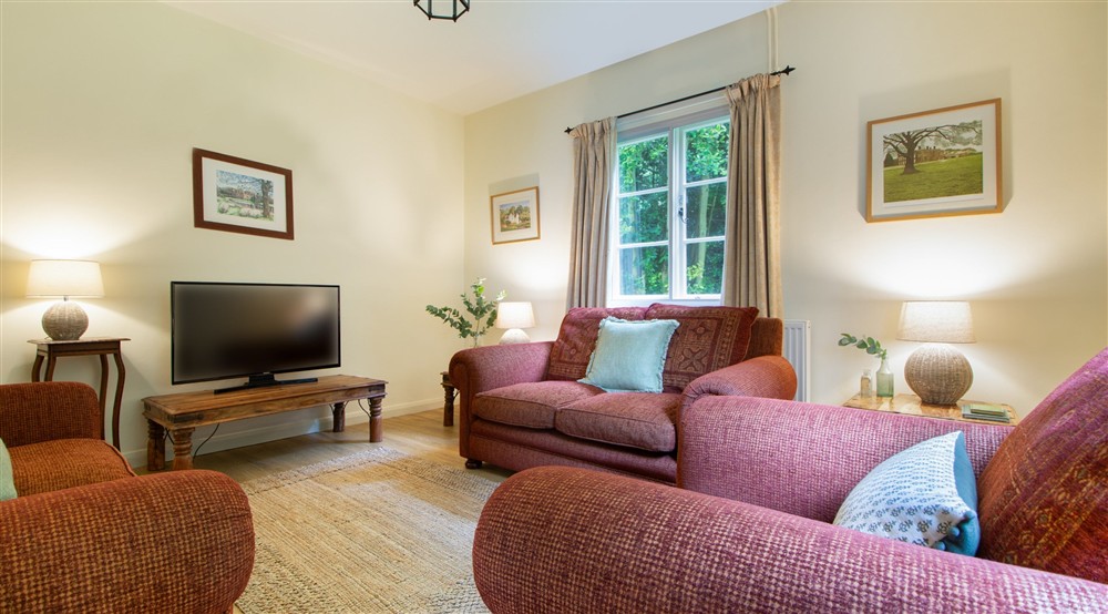 The sitting room with sofas and television, at Sexton's Lodge in Norwich, Norfolk