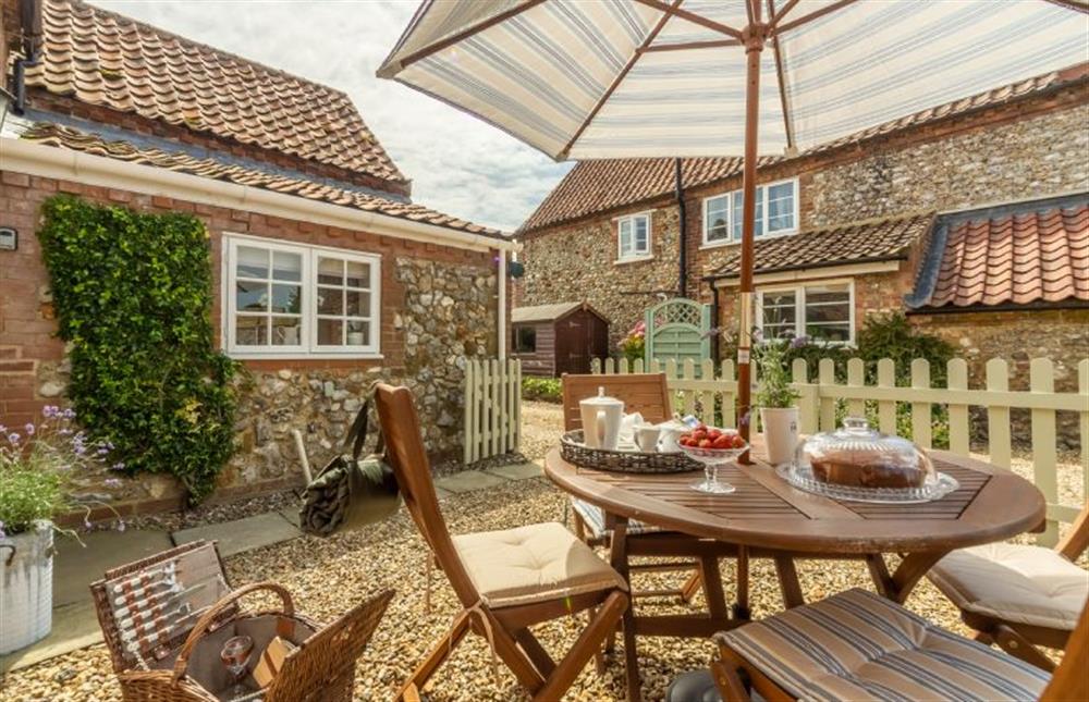 Enclosed courtyard with table and seating is a little sun trap at Sextons Yard Cottage, Docking near Kings Lynn