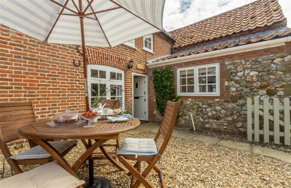 Outside there is an fully-enclosed courtyard with small table and seating for four at Sextons Yard Cottage, Docking near Kings Lynn