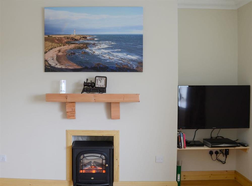 Living room with cosy electric woodburner at Sheaf Dale in Portmahomack, near Tain, Northern Highlands, Ross-Shire