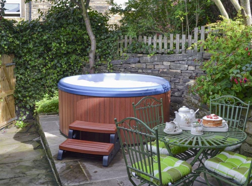 Enclosed courtyard with hot tub at Shelduck Cottage in Holmfirth, West Yorkshire