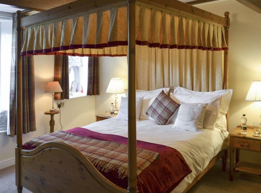 Master bedroom with four poster bed at Shelduck Cottage in Holmfirth, West Yorkshire