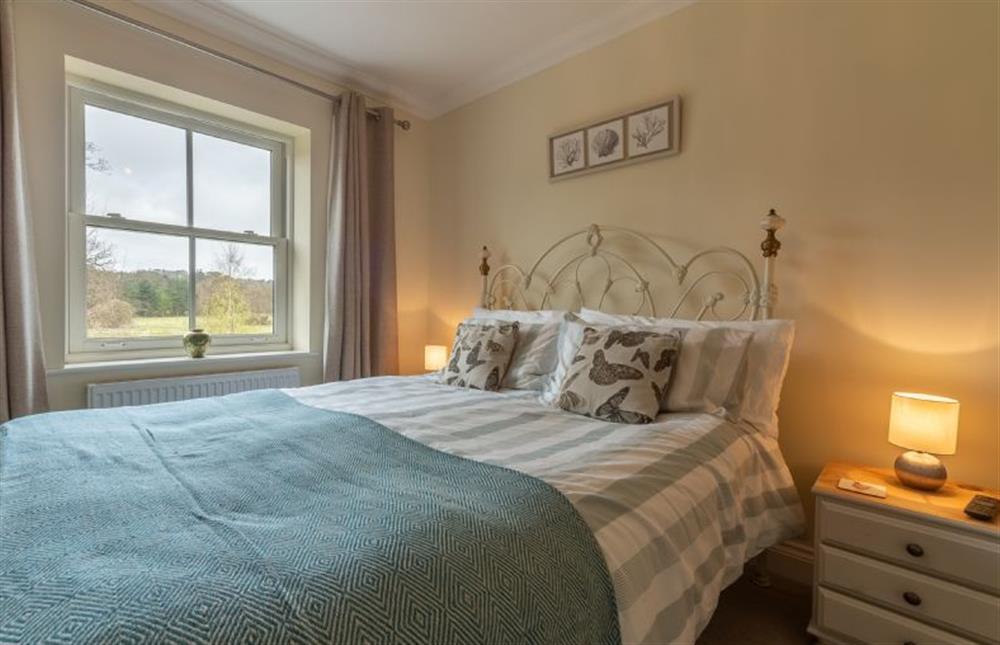 First floor: Master bedroom with pretty iron bedstead at Shellseekers, Snettisham near Kings Lynn