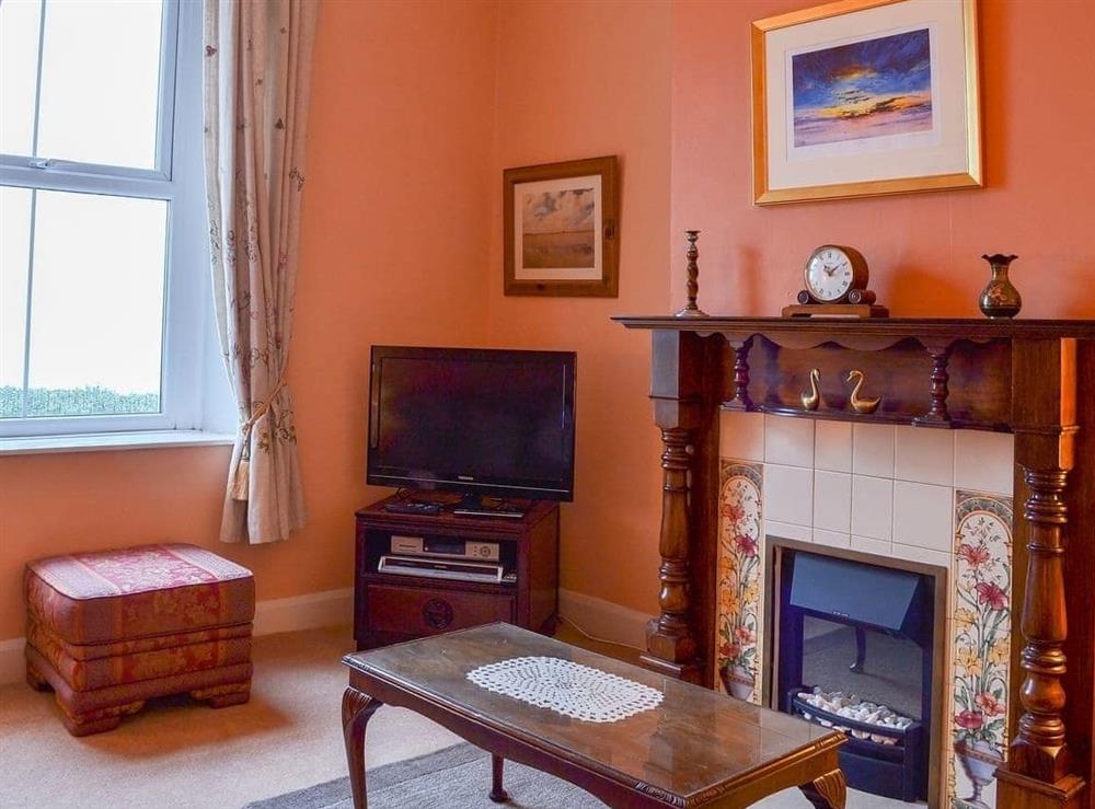 Light and airy living room with feature fireplace at Shingle Cottage in Seascale, near Eskdale, Cumbria