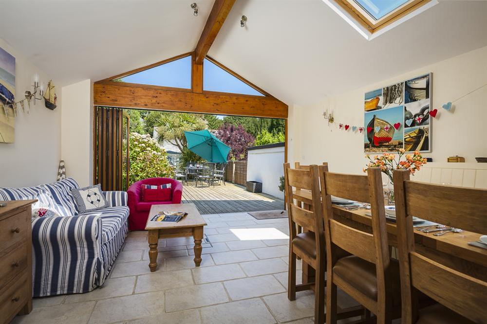 Dining area with comfortable seating leading to patio doors at Shipwrights in 11 Coronation Road, Salcombe