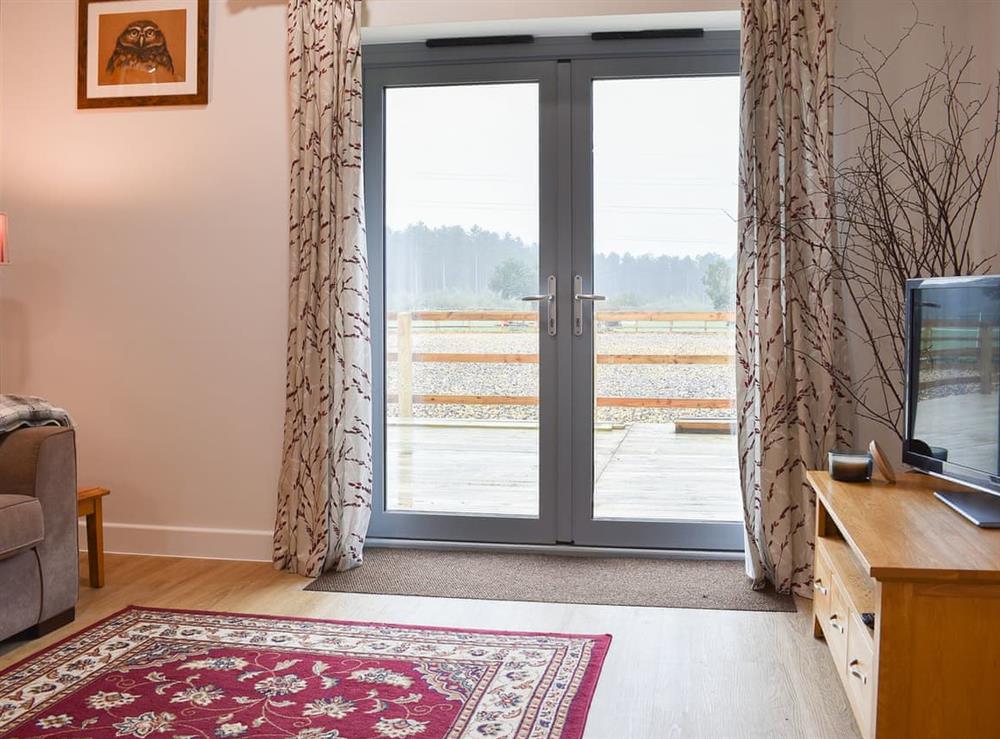 Comfortable living space with patio doors to the decked area at Sids Place in Ringwood, Dorset