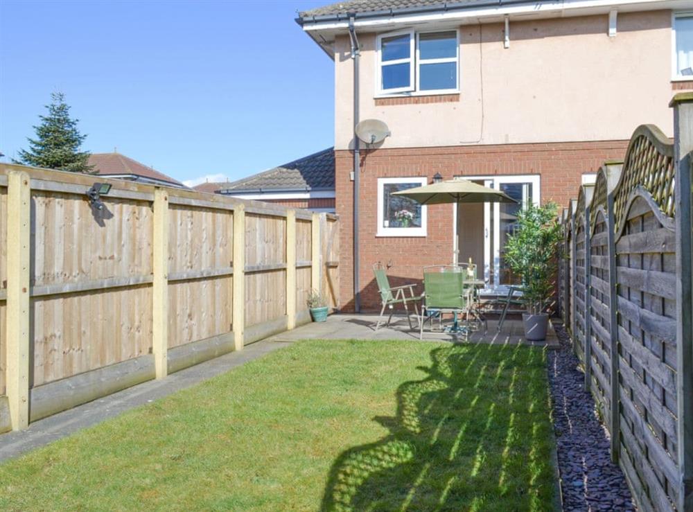 Enclosed lawned garden with outdoor furniture at Signals Court in Scarborough, North Yorkshire