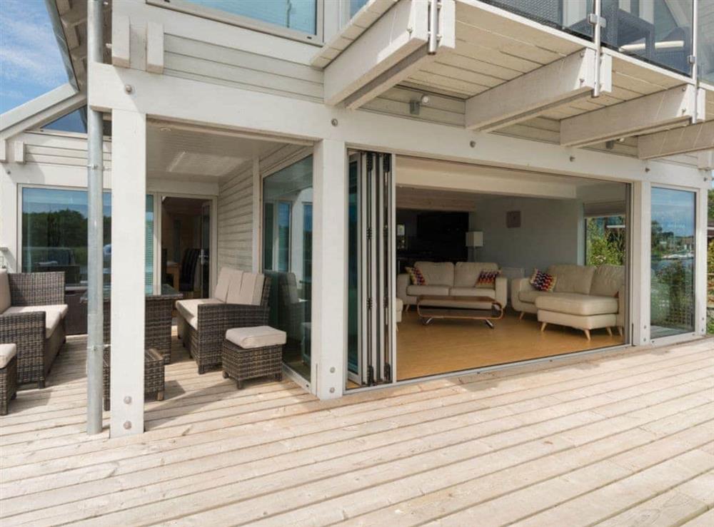 Outdoor furniture on decking and bi-fold doors to living area at Silver Dawn in Horning, near Wroxham, Norfolk