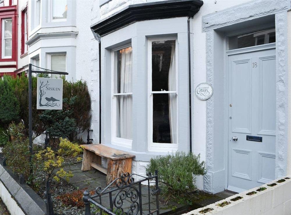 Traditional Lakeland home with bench seatin in the front garden at Siskin in Keswick, Cumbria