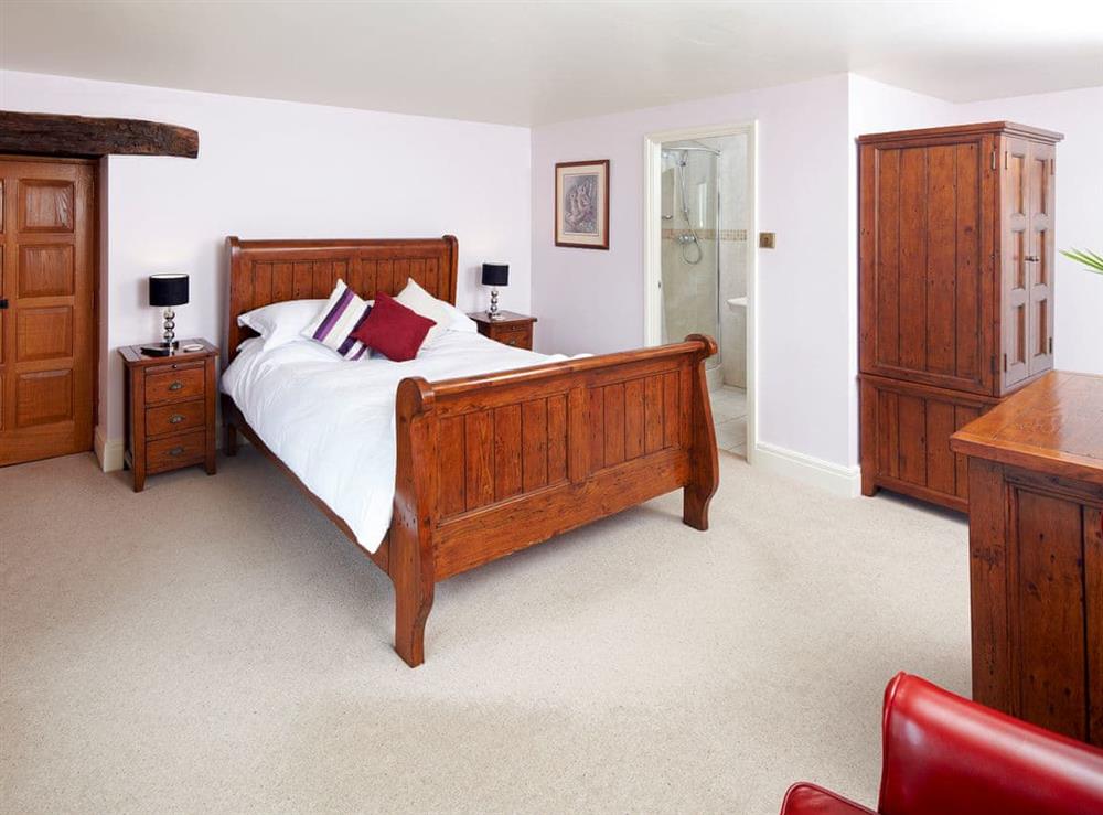 Bedroom with kingsize sleigh bed and en-suite at The Farmhouse, 