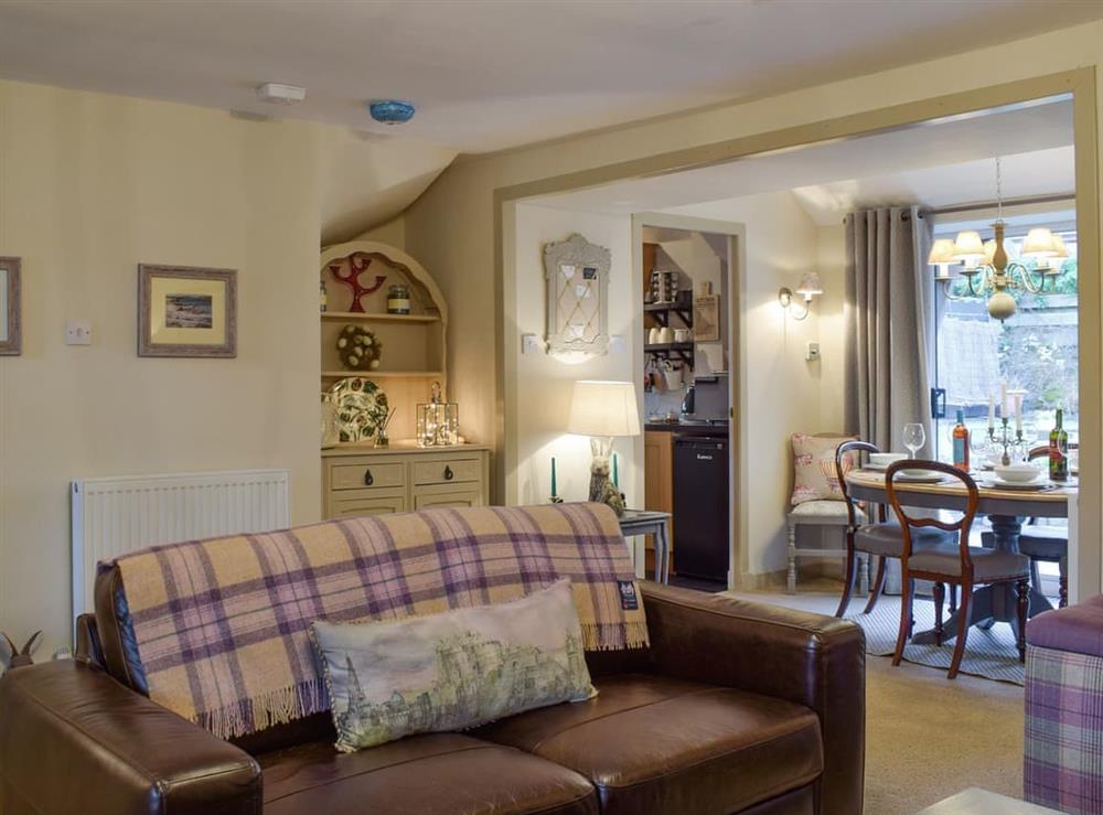 Spacious living room with open aspect to dining room at Smiddy Cottage in Weem, near Aberfeldy, Perthshire