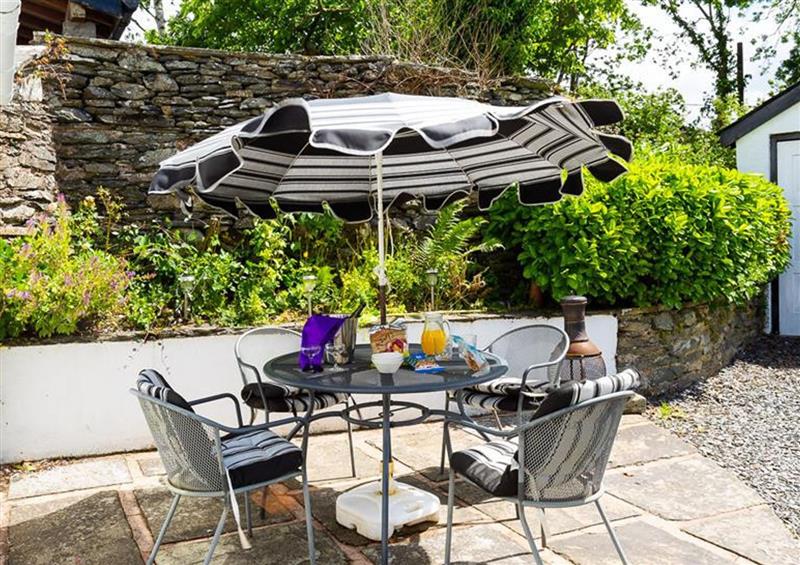 Enjoy a glass of wine on the patio at Smithy Cottage at Bowland Bridge, Bowness