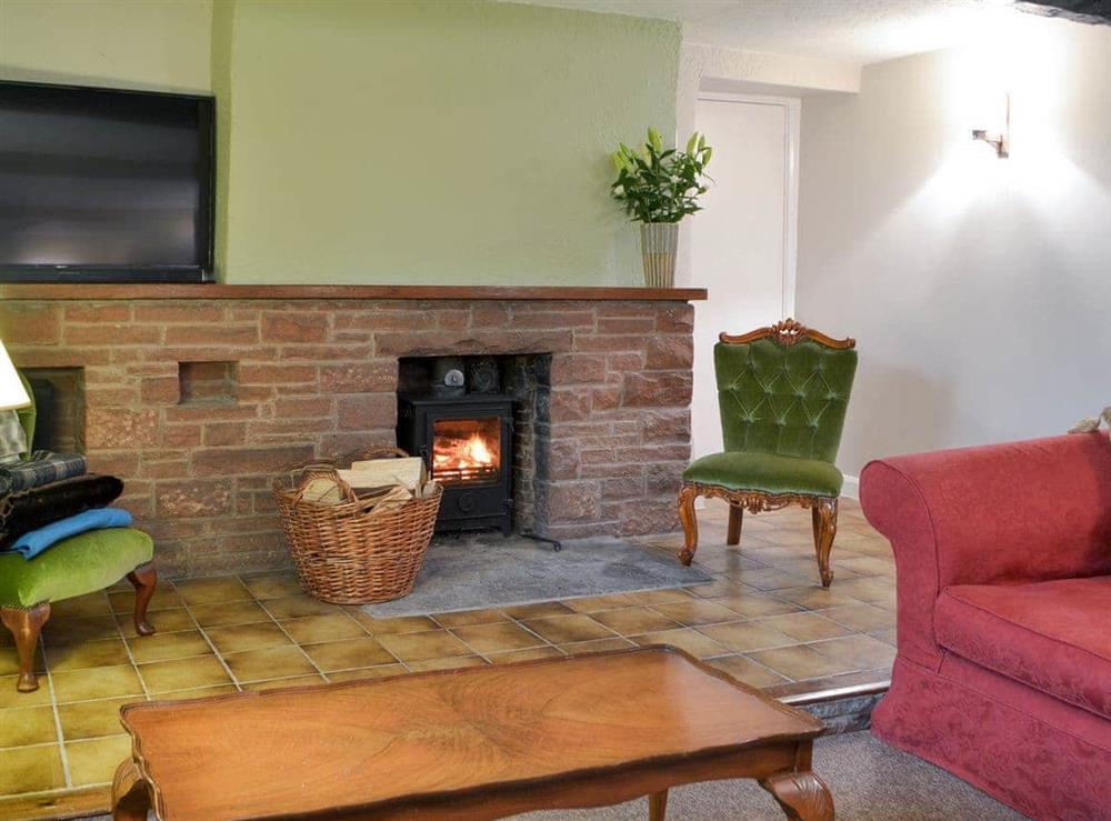 Good-sized, beamed living room with a wood burner (photo 2) at Smithy House in Bampton Grange, near Pooley Bridge, Cumbria