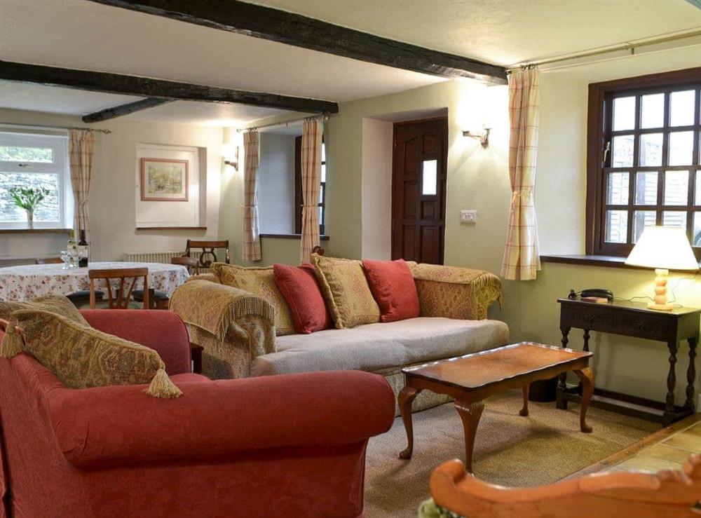 Good-sized, beamed living room with a wood burner at Smithy House in Bampton Grange, near Pooley Bridge, Cumbria