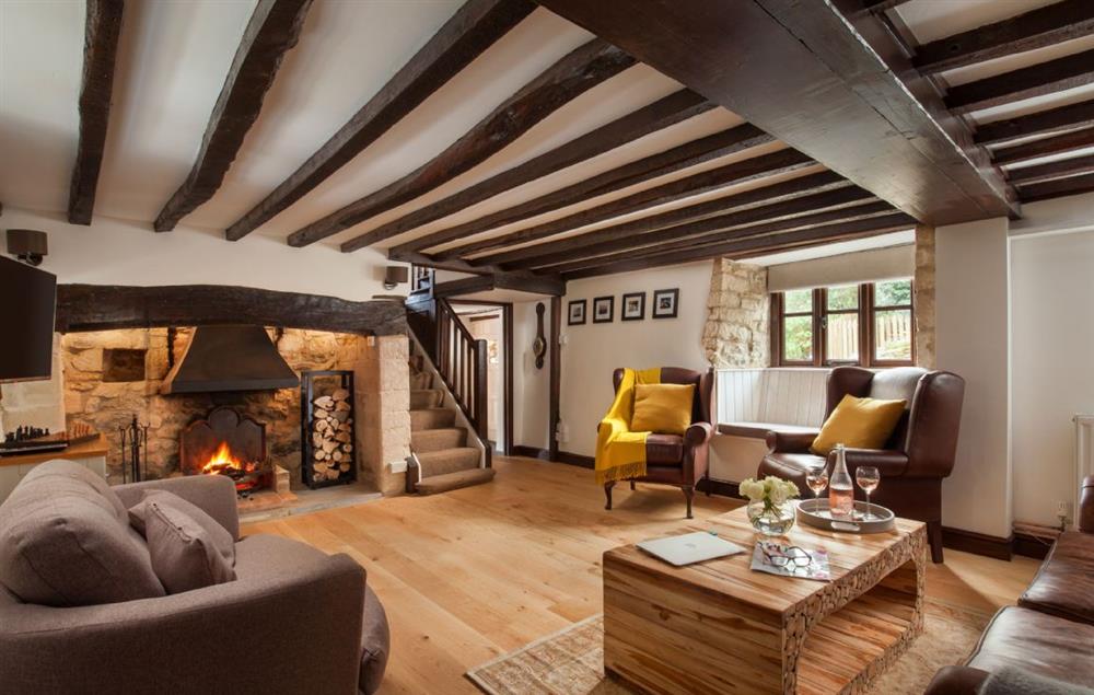 Original wooden beams and an open fire in the sitting room at Smithycroft, Combe St Nicholas