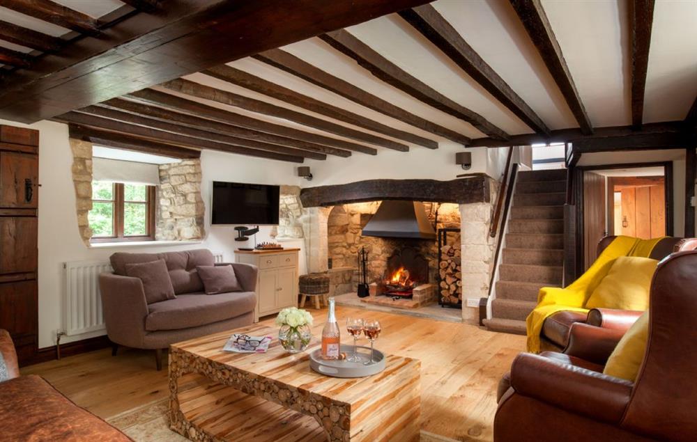 The stunning and inviting sitting room with inglenook fireplace and open fire at Smithycroft, Combe St Nicholas