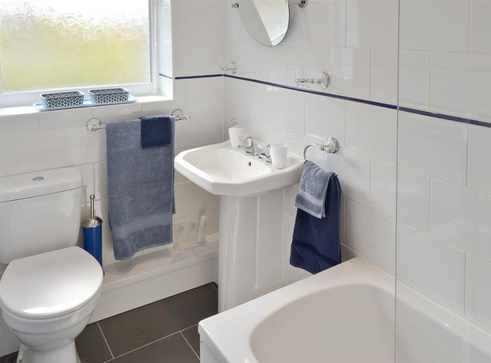 Family bathroom with shower over bath at Smitten Cottage in Rhyl, Denbighshire