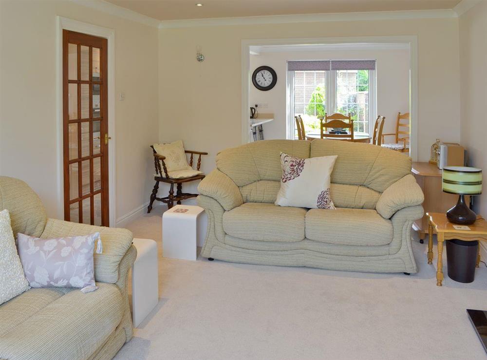 Open aspect living room adjoins dining area at Smitten Cottage in Rhyl, Denbighshire