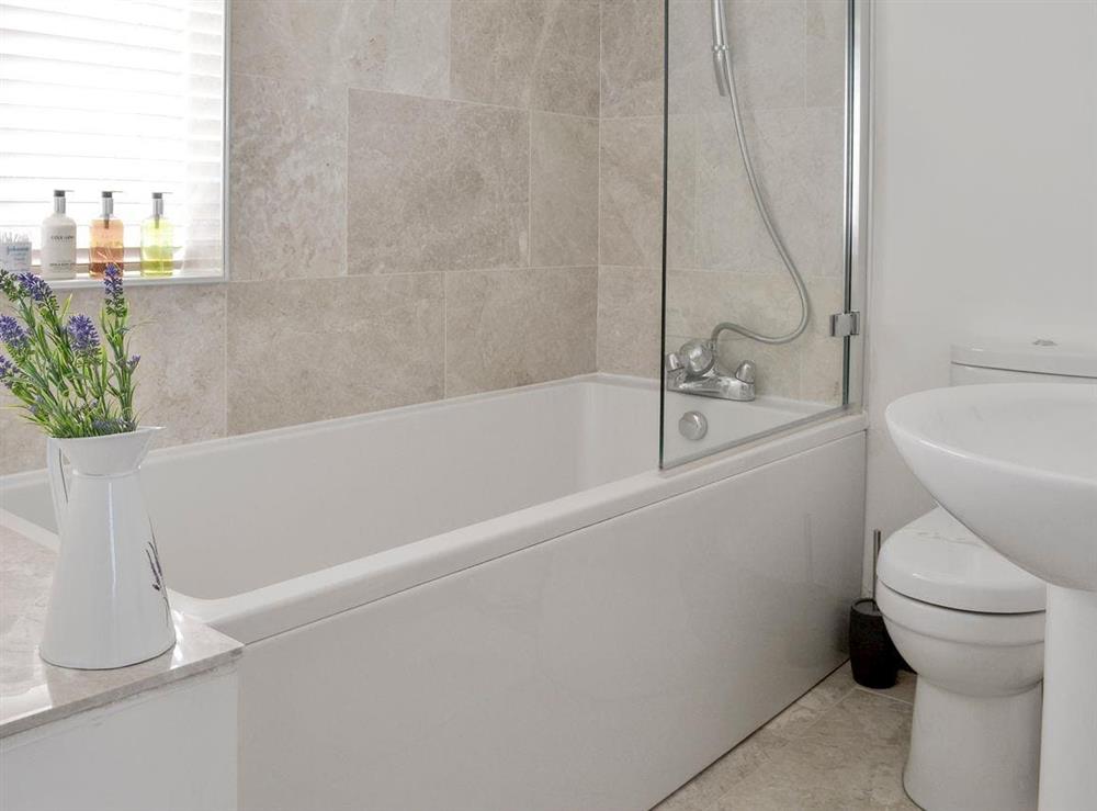 En-suite bathroom with shower over bath at Solitaire in South Creake, near Fakenham, Norfolk, England