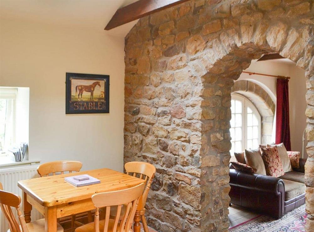 Charming dining area with stone archway from the living room at Cobweb Cottage, 