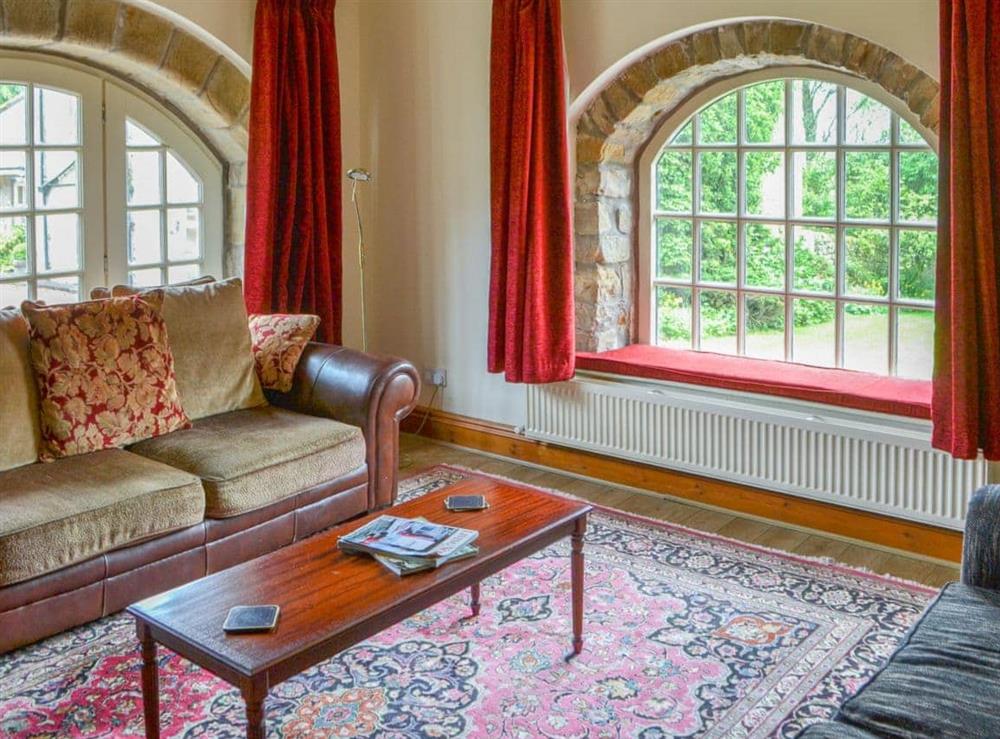 Grand living room with large arched windows at Cobweb Cottage, 