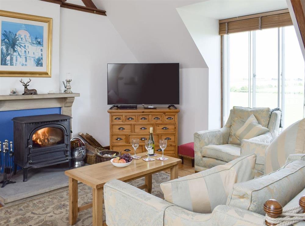 Welcoming living area with wood burner at South House in Lathones, near St Andrews, Fife