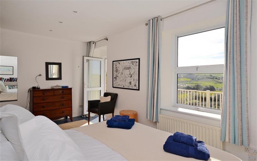 A view of the Master bedroom, with door to balcony and views over the golf course towards the sea at South Riding in Thurlestone