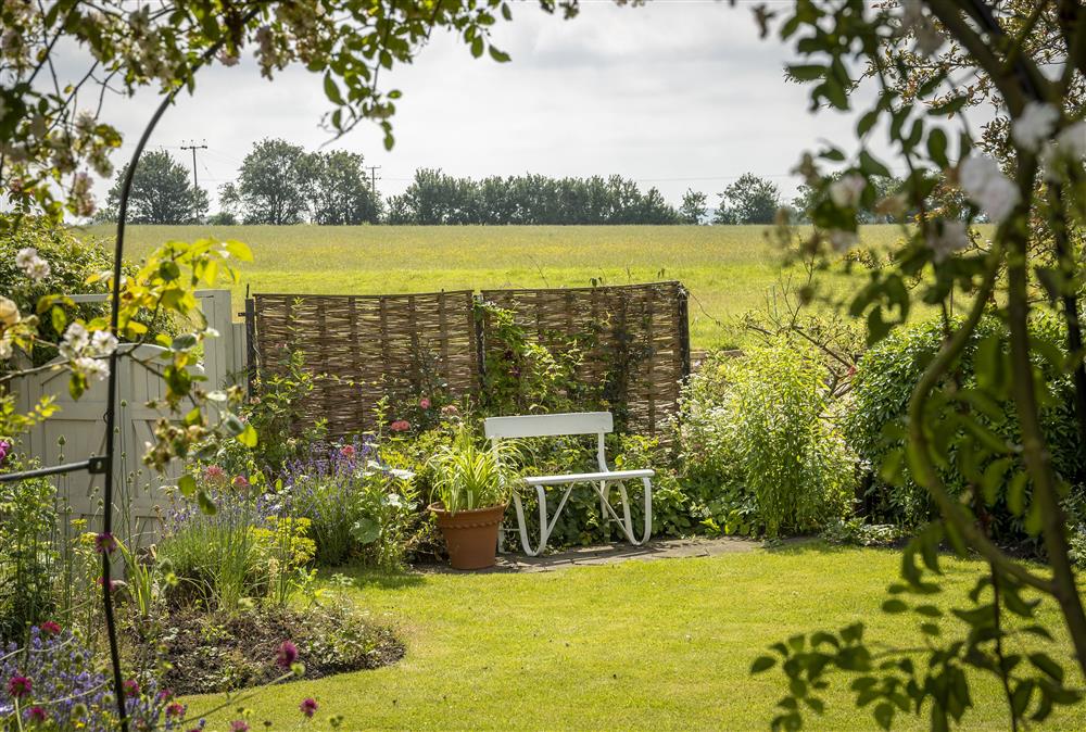 Enjoy the pretty garden with a book from the ownerfts bookcase at Southcroft Cottage, Bredons Norton