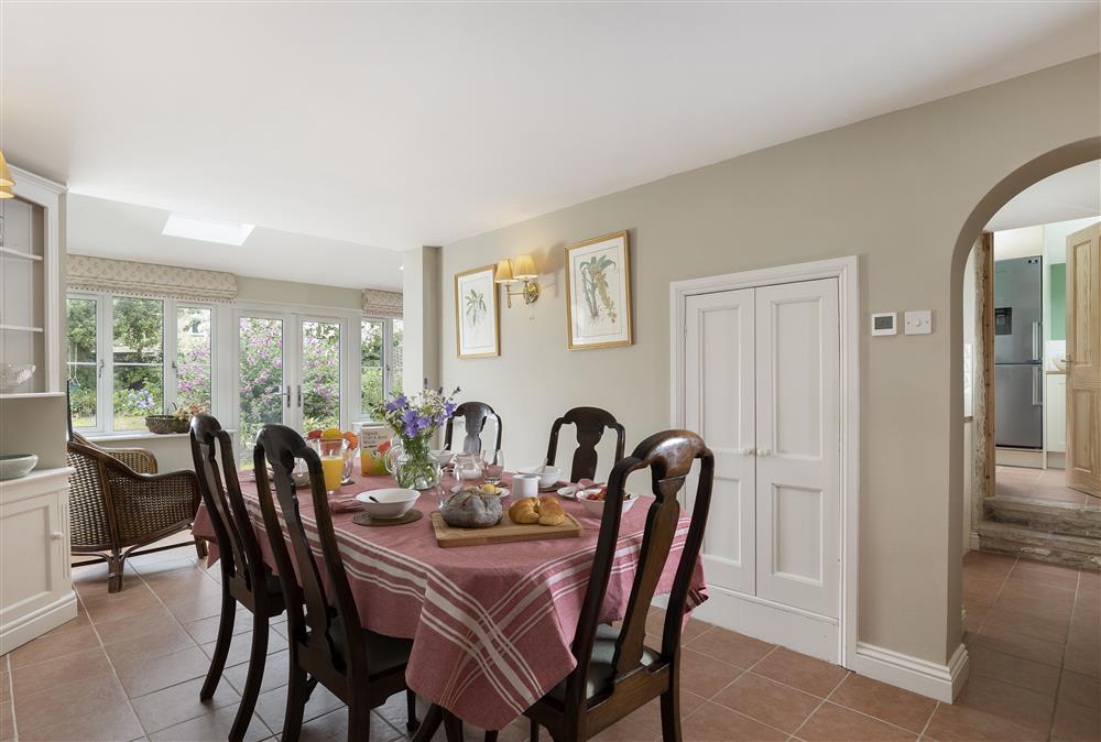 Ground floor: Dining room with seating for six guests leading into the garden room (photo 2) at Southcroft Cottage, Bredons Norton