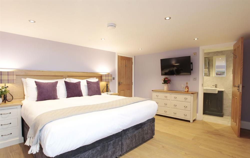 First floor: Double bedroom with zip and link bed, en suite and views onto front lawn and reservoir