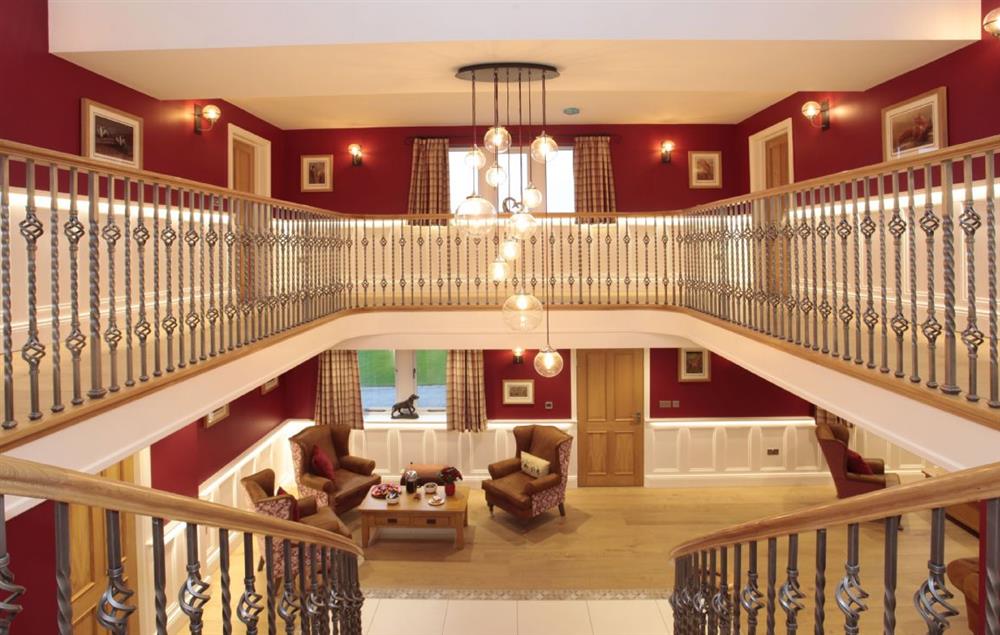 Grand hall with an elegant curved oak staircase leading up to the first floor at Spicer Manor, Ingbirchworth