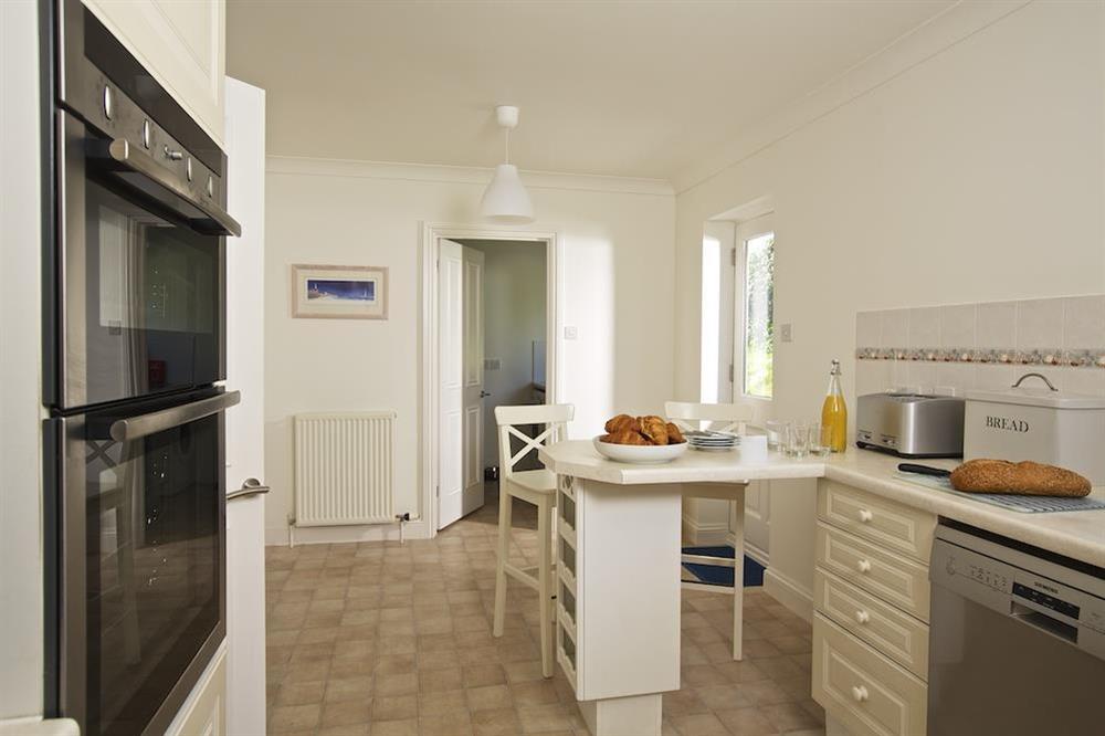 Well-appointed kitchen with breakfast bar, adjacent to the entrance of the utility area at Spindrift in , Thurlestone