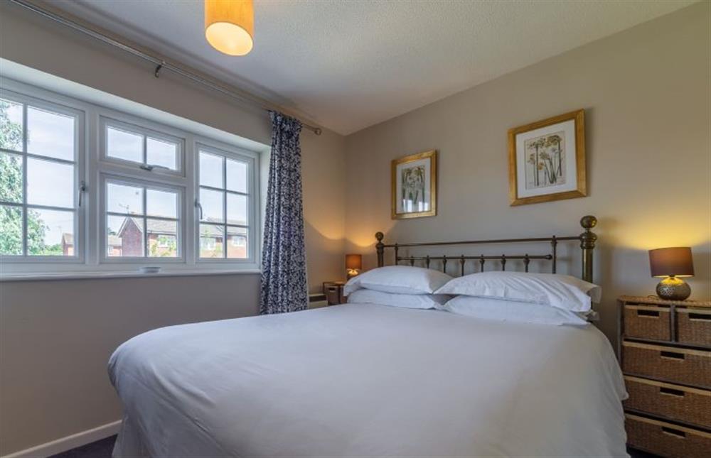 First floor: Master bedroom has king-size bed and large windows at Spinnakers, Brancaster Staithe near Kings Lynn