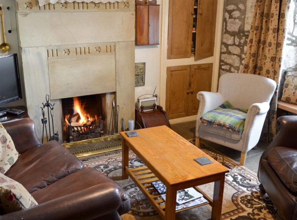 Living room with open fire at Spoutscroft Cottage in Austwick, near Settle, North Yorkshire