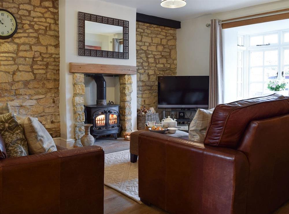 Cosy living room with wood burner at Spring Cottage in Bourton-on-the-Water, Gloucestershire