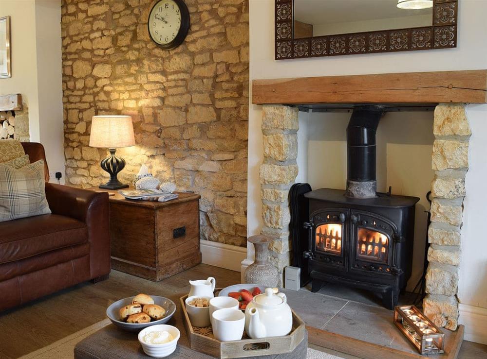 Living room with wood burner at Spring Cottage in Bourton-on-the-Water, Gloucestershire