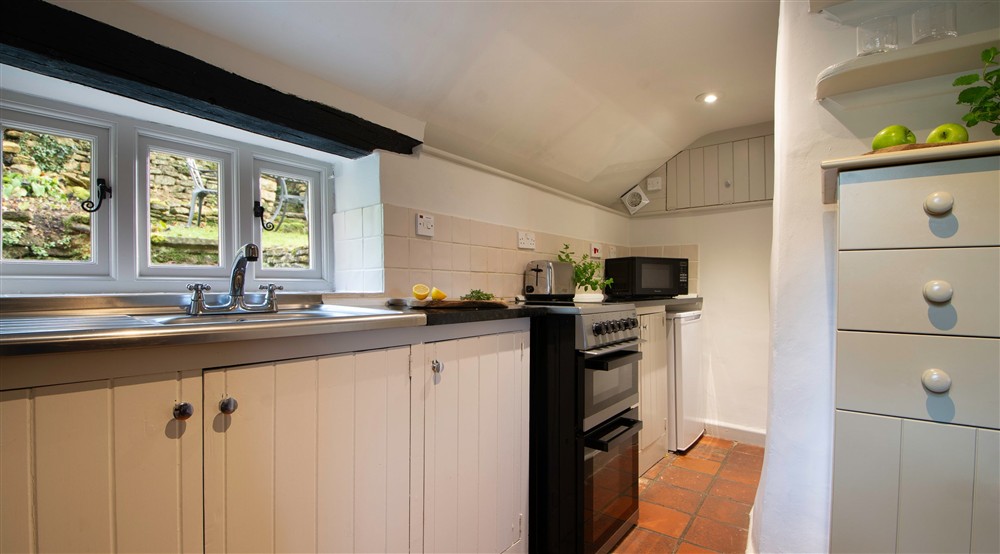 The kitchen with views of the rear garden at Spring Cottage in Broadway, Gloucestershire