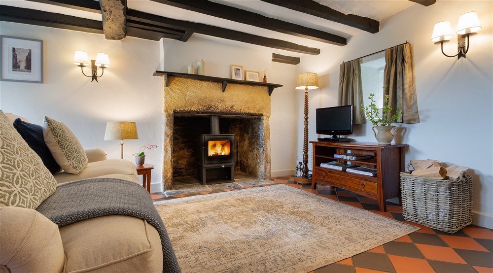 The open-plan sitting and dining room with television at Spring Cottage in Broadway, Gloucestershire